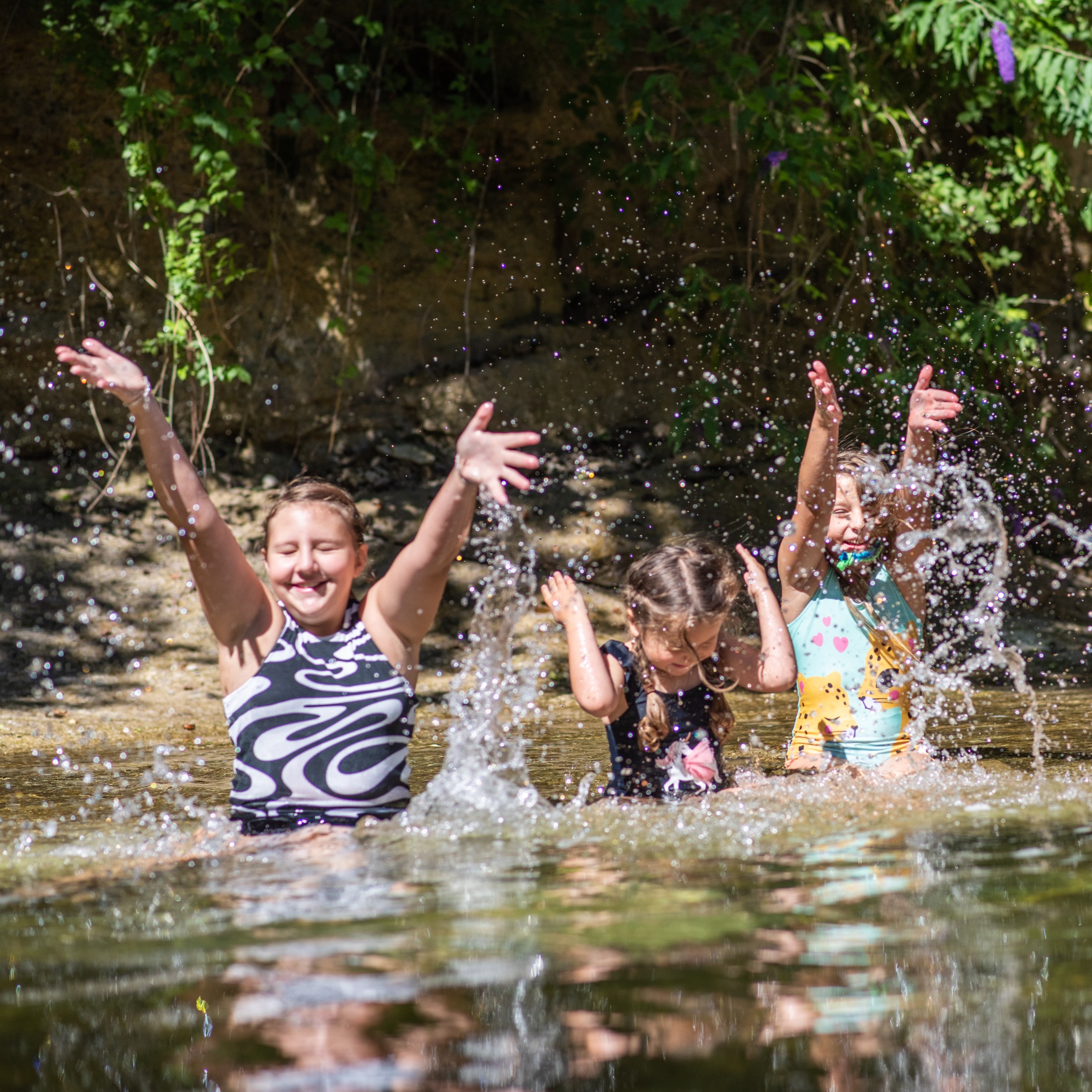 M&auml;dchen spritzen ausgelassen im Wasser eines Bachs